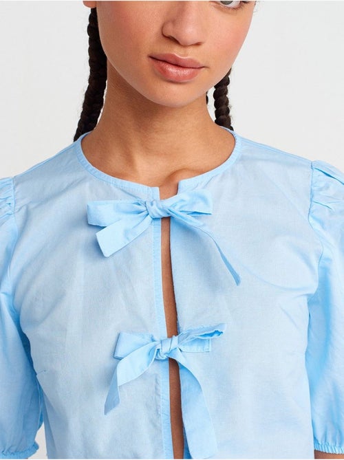 Blusa crop da donna con dettaglio fiocco dilvin - Kiabi Blusa crop da donna con dettaglio fiocco dilvin - Kiabi