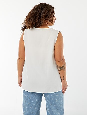 Blusa tinta unita con cucitura fantasia sul collo