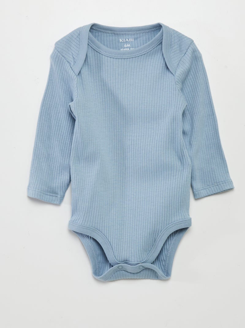 Giovane uomo serio in camicia blu scuro e cravatta isolato su bianco Foto stock