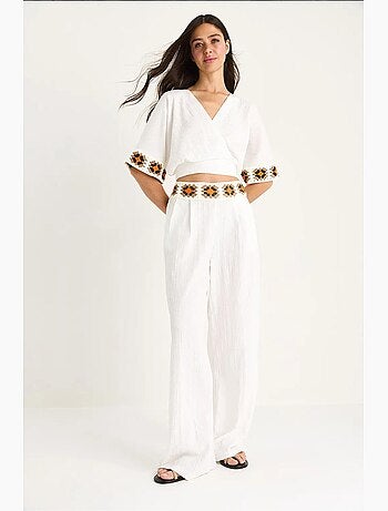 Completo pantaloni a vita alta con cintura e colletto incrociato in maglia bianco lucci