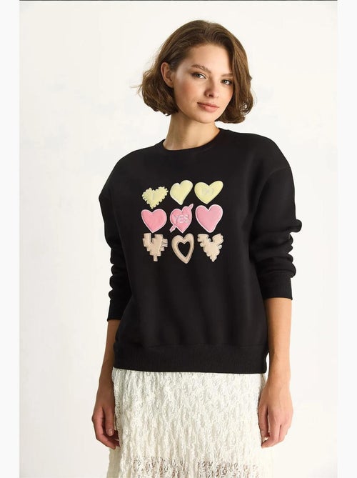 Felpa girocollo relaxed fit con applicazioni a patch a cuore lucci - Kiabi Felpa girocollo relaxed fit con applicazioni a patch a cuore lucci - Kiabi