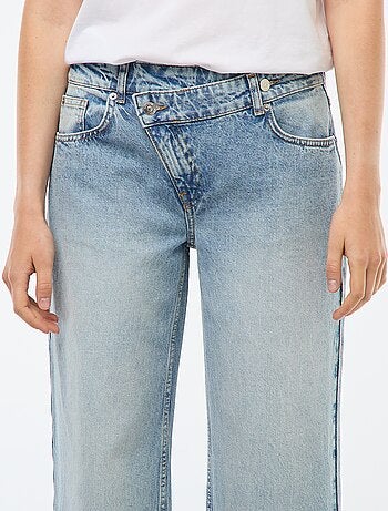 Jeans a gamba larga e vita alta con cintura asimmetrica