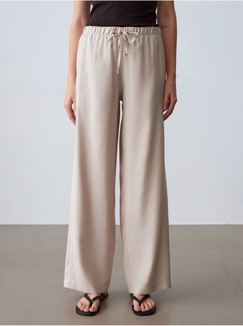 Pantaloni a gamba ampia con vita elasticizzata e coulisse dilvin Sabbia - Kiabi