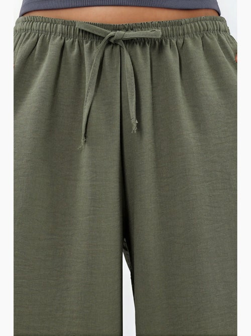 Pantaloni in tessuto a gamba larga con vita a coulisse busem - Kiabi Pantaloni in tessuto a gamba larga con vita a coulisse busem - Kiabi