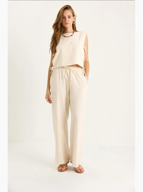 Set co-ord a due pezzi con girocollo, chiusura con laccetti e pantaloni a gamba ampia lucci - Kiabi Set co-ord a due pezzi con girocollo, chiusura con laccetti e pantaloni a gamba ampia lucci - Kiabi