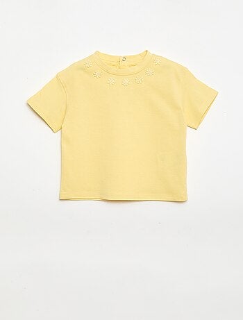 T-shirt a tinta unita con fiori fantasia sul colletto