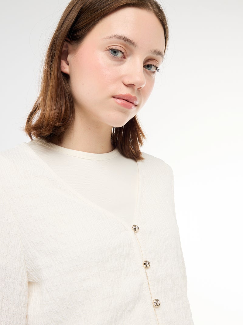 Top a collo a V in maglia goffrata con bottoni dorati Bianco - Kiabi